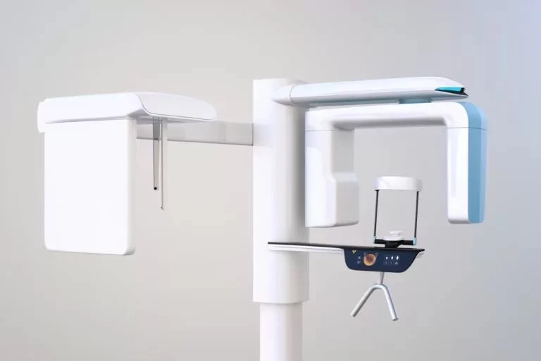 Modern cone beam computed tomography (CBCT) machine used for detailed 3D imaging of a patient's dental structures, consisting of a central column with an arm that holds the X-ray source and detector, rotating around the patient's head.