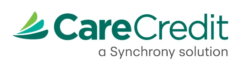The image shows the logo for CareCredit, a healthcare credit card service. The logo features three green and teal swoosh-like shapes on the left, with "CareCredit" written in bold green text next to it. Below, the tagline "a Synchrony solution" appears in a smaller gray font, representing its affiliation with Synchrony Financial.